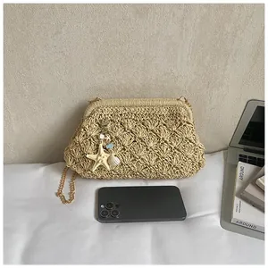 Detail of woven straw bag with starfish charm and golden chain for size reference