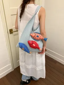 Grand sac cabas en tricot bleu clair avec poissons colorés en 3D porté à l'épaule