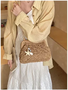 Detail of hand-woven straw bag with seashell charms and metal chain for summer travel