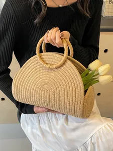Große Strohtasche mit runden Griffen und gewebter Textur für den Sommerurlaub am Strand