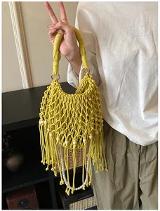 Close-up of yellow woven beach bag featuring intricate crochet details and fringe tassels