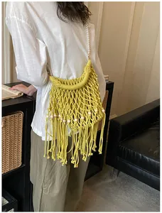 Model wearing yellow bohemian woven beach bag with tassel detail and pearl chain
