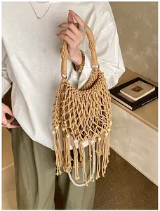 Detailed view of bohemian woven bag featuring long tassels with pearls and wooden beads