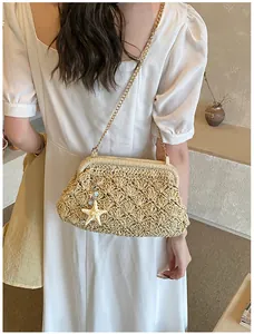 Detailed close-up of woven straw cloud bag with gold chain and starfish charm pendant