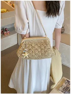 Close-up of beige woven straw shell bag with gold chain and starfish charm detail