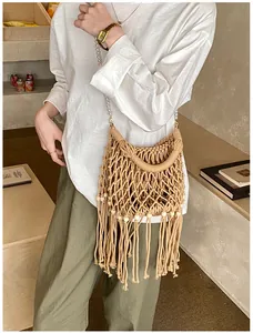 Detail of bohemian woven bucket bag with tassels, wooden beads, and pearl strap