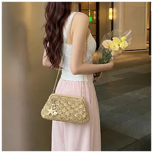 Detailed texture of wave-woven straw bag with gold chain and shell star pendants