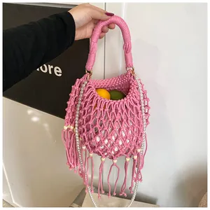Pink hand-crochet beach bag detail with long fringes and pearl chain strap