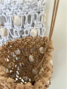 Detail of bohemian hand-woven mini bags with natural seashells and cotton rope texture