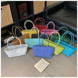 Gros plan de sacs paniers en plastique tissé colorés avec doubles poignées en divers coloris