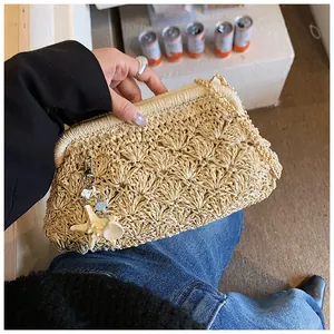 Detail view of woven straw bag texture with sea-inspired shell and starfish charms