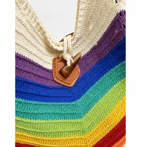 Nahaufnahme der Hornschnalle und Lederpatch auf der regenbogenfarben gestrickten Tragetasche