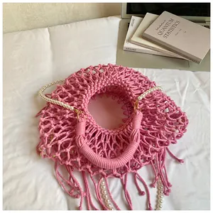 Pink bohemian woven bag featuring circular macramé texture and pearl handle detail