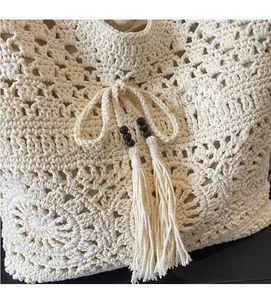 Detail of woven cotton tote bag with intricate openwork mesh and wood bead tassel