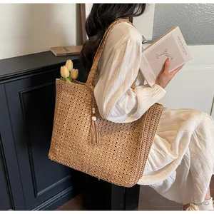Détails du sac cabas en paille tissé avec glands en perles de bois et bandoulière