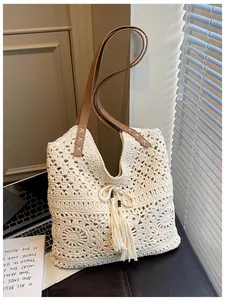 Detaillierte Nahaufnahme der weißen Häkeltasche mit Blumenmuster und Lederriemen