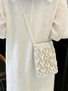 Bohemian hand-woven white crossbody bag with natural shell accents for summer vacation