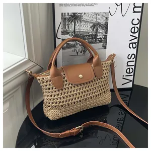 Detailed macro view of woven straw mesh material with premium brown leather strap on bag