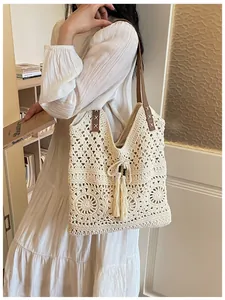 Detail der Boho-Häkeltasche mit hohlem Blumenmuster und Quasten mit Holzperlen