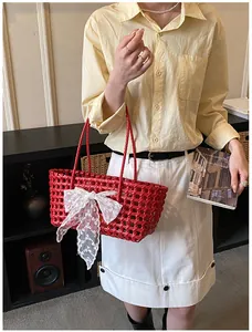 Détail du panier tressé rouge avec un grand nœud en dentelle blanche en intérieur