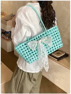 Détail du sac cabas tressé vert menthe avec un nœud en dentelle blanche en situation