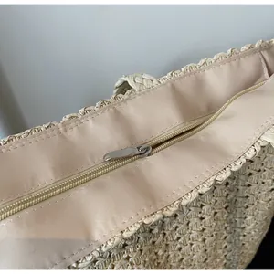 Gros plan du sac de plage en paille avec fermeture éclair et doublure en tissu rose