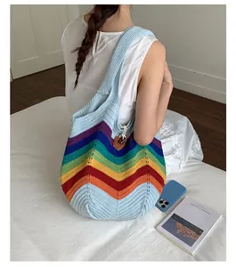 Detail der bunten Regenbogen-Häkeltasche mit braunem Leder-Steckverschluss