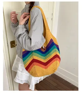Detail der gestreiften Regenbogen-Stricktasche mit Textur und braunem Lederverschluss