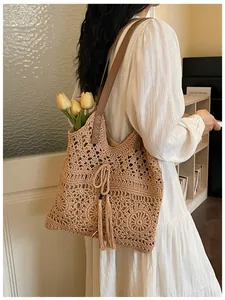 Detail der Boho-Häkeltasche mit floralem Lochmuster und Leder-Schultergurt