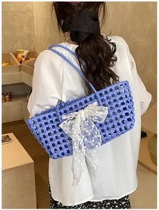 Sac cabas bleu tressé avec grand nœud en dentelle blanche et bandoulières longues
