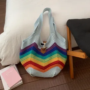 Detail einer bunten Stricktasche mit Regenbogenstreifen und Holz-Knebelverschluss