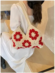 Close-up of handmade floral granny square crochet pattern on bohemian shoulder bag