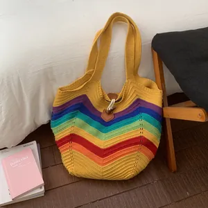 Makro-Detail der Regenbogen-Stricktasche mit bunten V-Streifen und brauner Lederschnalle