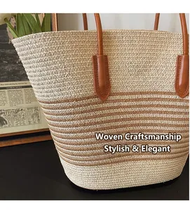 Dettaglio della borsa tote in paglia a righe beige e marrone con trama intrecciata e manico in pelle