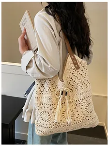 Detailaufnahme der Häkel-Tasche mit floralem Lochmuster, Quasten und Holzperlen-Deko