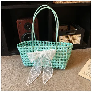 Détail du sac de plage tressé vert menthe avec nœud en dentelle sur étagère vintage