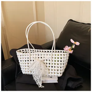 Détail du panier tressé blanc ajouré avec un élégant nœud en dentelle et broderies