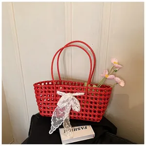 Détail du panier tressé rouge avec nœud en dentelle et deux poignées pour la plage d'été