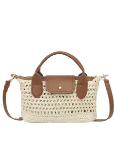Minimalist woven straw crossbody bag with brown leather handles for summer beach use