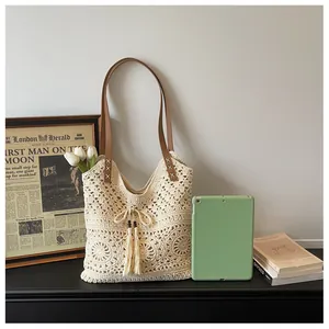 Detail of hand-woven cotton tote bag featuring tassels with wooden beads and leather straps