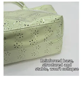 Close-up of the reinforced bottom and floral laser-cut patterns on the green tote bag