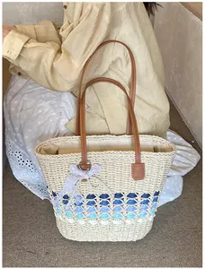 Detail of woven straw tote bag with blue gradient finish and pearl lace charms