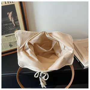 Detail view of the woven bag featuring a zip closure, fabric lining, and inner pocket