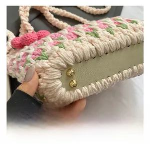 Detailed view of golden metal studs on the bottom of handmade crochet flower bag