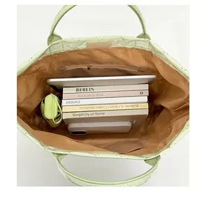 Detailed interior view showing large capacity and internal pockets of the green tote bag