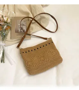 Close-up of bohemian woven crossbody bag with floral patterns and bead trim detailing