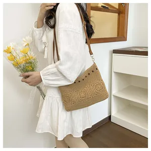 Detail of hand-woven straw bag with crochet sunflowers and leather strap on a lace dress