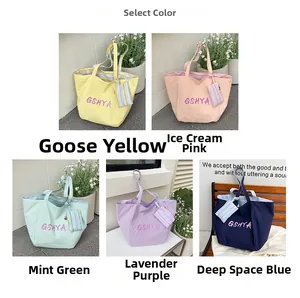 Detalle de colección de bolsos tote grandes en cinco colores con estuches de rayas