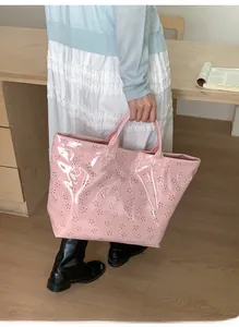 Detail of pink jelly tote bag with laser-cut floral patterns and top handles