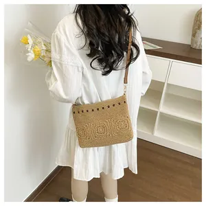 Detail of bohemian hand-woven straw crossbody bag with floral crochet patterns